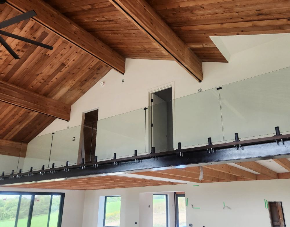 Glass railing installation on an active custom-build job site